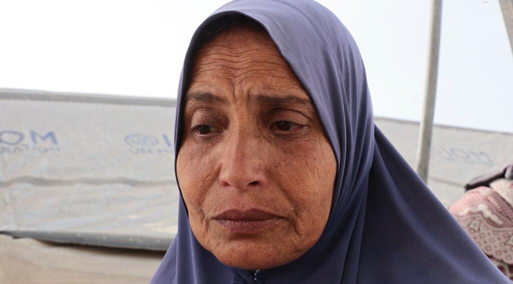 السيدة الفلسطينية أم أحمد حمودة، تجلس أمام خيمتها في غزة متحدثة عن الواقع الصعب للنزوح وحياة الخيام. نزحت مع أسرتها 4 مرات خلال العامين الماضيين.